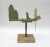 Whimsical avocado green whirligig depicting a man in a canoe / boat smoking a pipe. The green platform has a full 360...