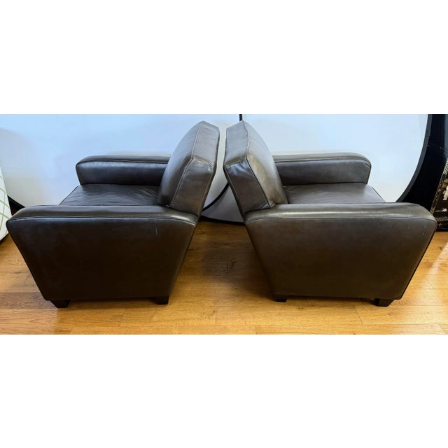Classic pair of brown leather club chairs. Featuring rich, supple leather upholstery in a sophisticated deep brown, each...