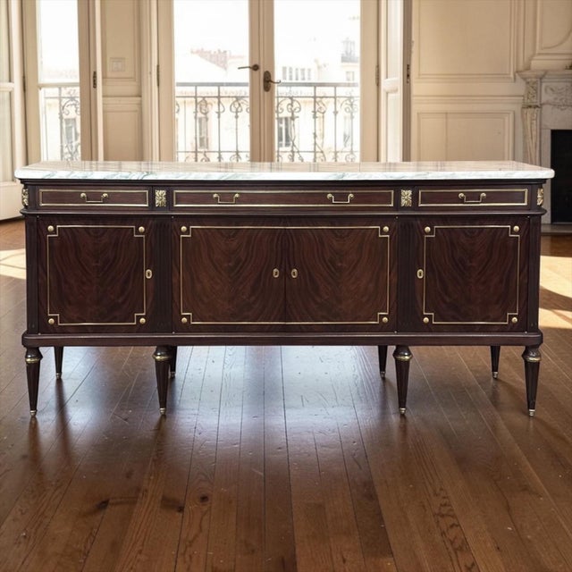 19th Century French Louis XVI Mahogany Buffet with Carrara Marble Top is a commanding and impressive work of the...