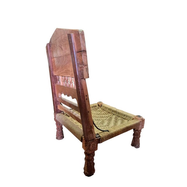 Pair of handcrafted low chairs from India, made of solid wood with a natural rope woven seat. The backrests feature...