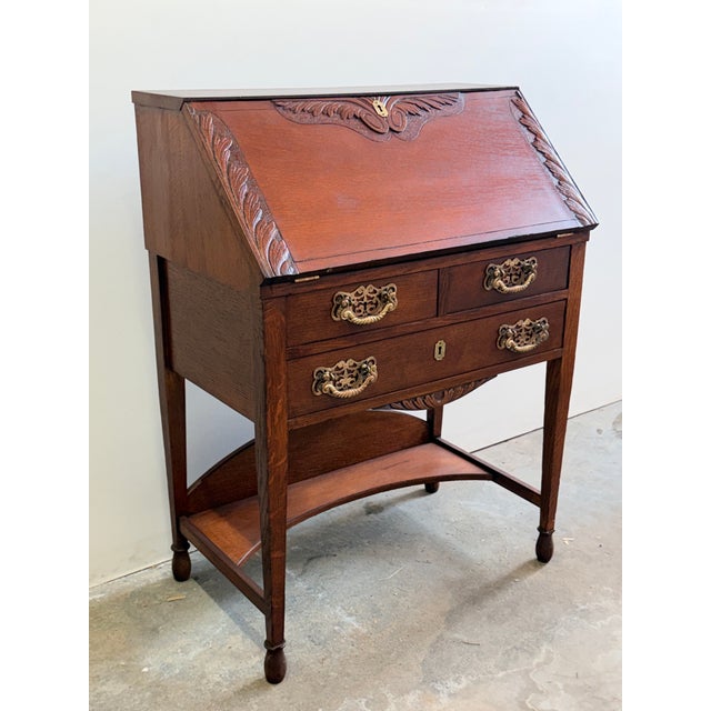 Antique Victorian Slant Front Carved Secretary. Slant front opens to reveal pigeonhole compartments, 2 drawers, and center...