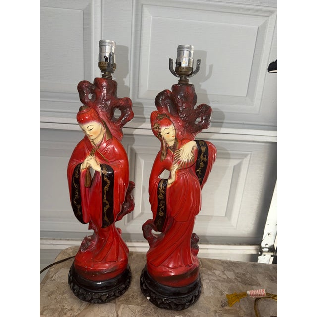 A striking pair of mid-20th-century Chinoiserie figural table lamps, dating to the late 1940s or 1950s. These lamps are...