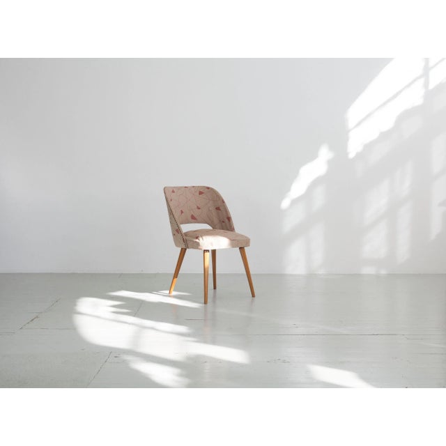 The relatively small cocktail chair covered with a solid vinyl cover, the seams of which are stabilized by a white piping....