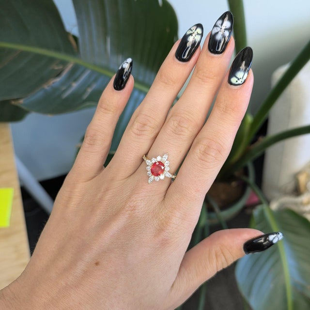 A rare padparadscha sapphire glows in its signature lotus blend of pink and orange, framed by earth-mined diamonds in...