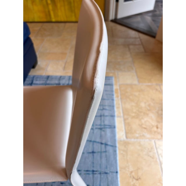 Sold as a pair: Elegant ivory cream bonded leather dining chairs from Room & Board. This pair has a minimalist design with...