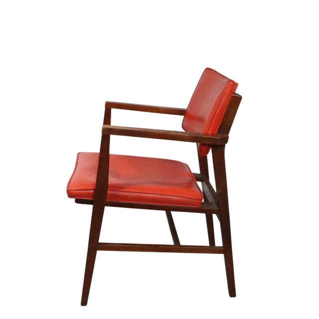 Classic Mid Century arm chair, having an. architecturally designed frame, with original orange vinyl seat and backrest....