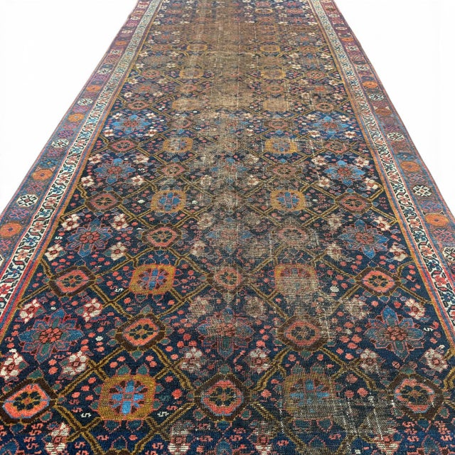 This antique Veramin runner from Central Asia showcases a refined and richly detailed allover floral design,...