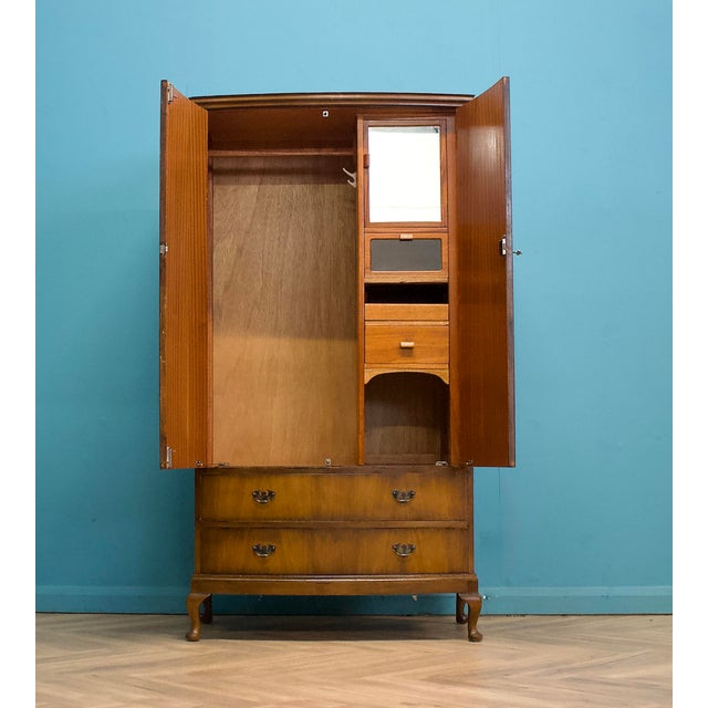 Attractive wardrobe in beautifully figured burr walnut, with book-matched doors, moulded panels and slender cabriole legs...