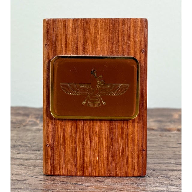 This mid century teak wood desk object features a recessed amber tone lucite plaque engraved with the Faravahar, the...