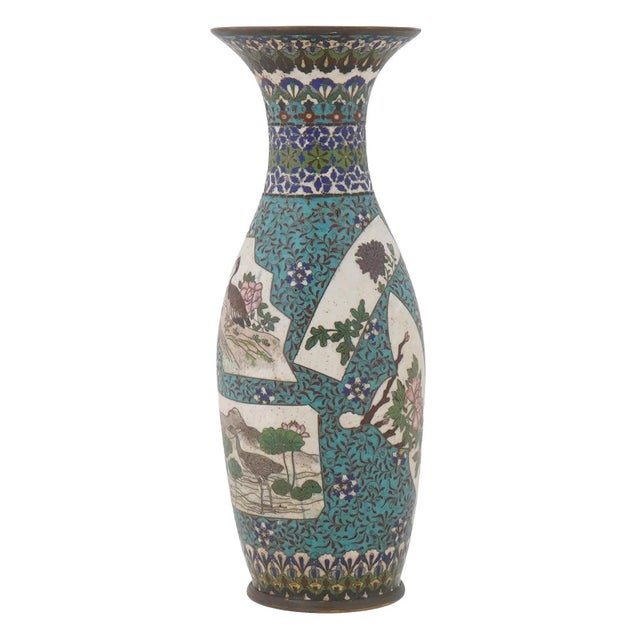 An antique Japanese cloisonne enameled vase with a slender, curved body and a flared neck. The vase is decorated with...
