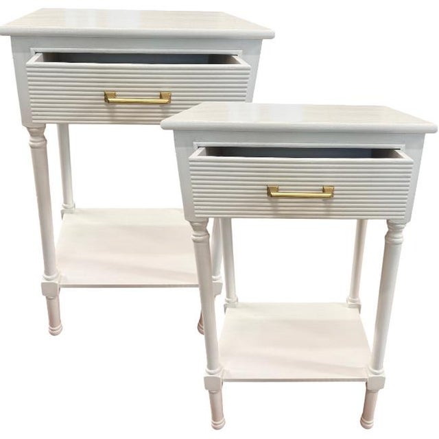 A pair of coastal-inspired one-drawer nightstands featuring elegant faux bamboo turned legs and a lower display shelf for...