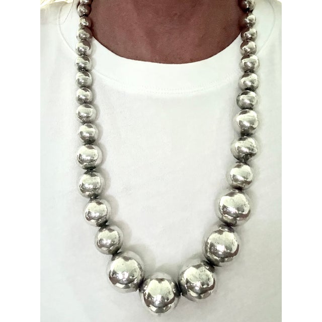 A substantial vintage Taxco sterling silver necklace composed of graduated hand-fabricated beads, tapering from smaller...