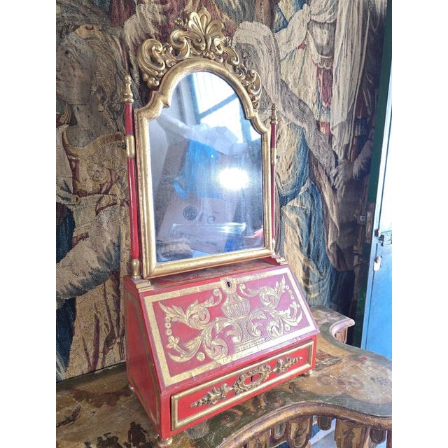 An exceptional and highly decorative 18th-century European dressing table and writing desk, executed in red lacquered wood...