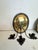Pair of antiqued hand hammered brass and iron candle sconces having oval backs and rustic 3 arm candle holders. SW