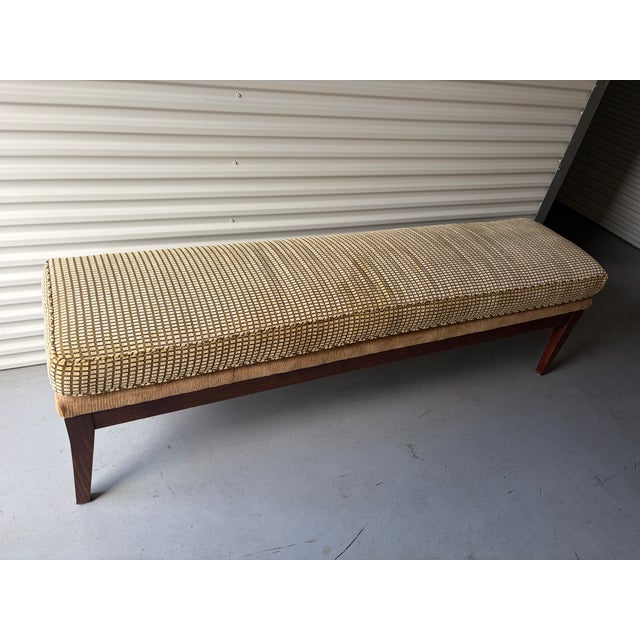Custom-made upholstered bench with tapered walnut legs and a woven geometric fabric in gold, cream, and black. Clean-lined...