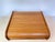 Vintage teak storage box with a rounded, curved-top silhouette and a smooth sliding tambour (roll-top) door with slatted...