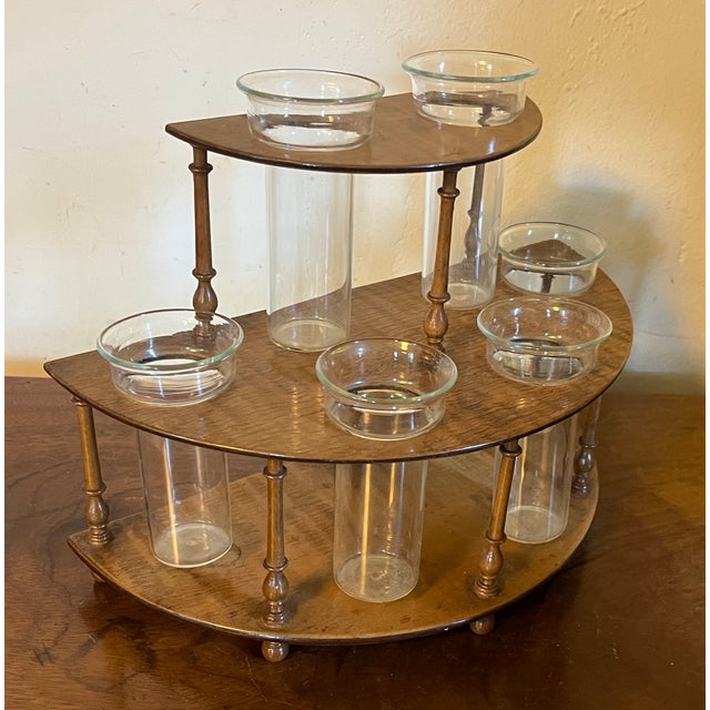 English tiger maple two tier flower holder in the Regency style. Crescent shape with turned baluster supports and ball...