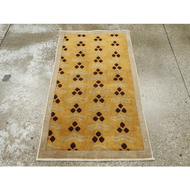 A vintage Turkish Anatolian Art Deco throw rug handmade during the mid-20th century with a goldenrod field and silver-grey...