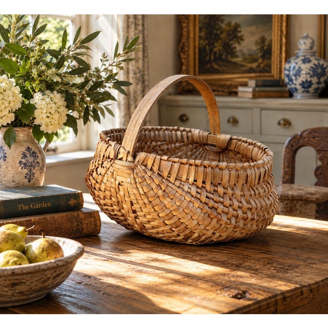 A generously scaled late-19th-century gathering basket, handwoven from narrow oak splints around a sturdy fixed bentwood...