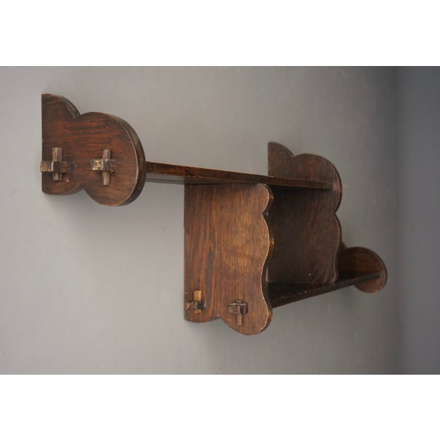 A Dutch 1930s oak and pine wall shelving unit with peg construction. The are two steel support brackets to the back.
