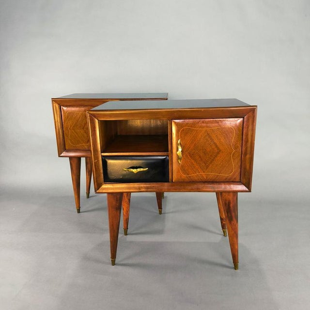 Pair of bedside tables with black glass and stiletto legs, designed in the 1950s. Structure in solid mahogany and veneer,...