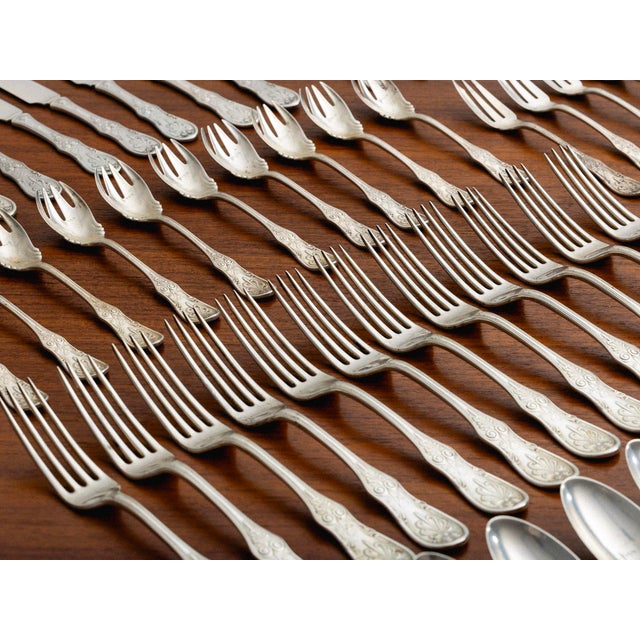 Tiffany & Co. Saratoga pattern sterling silver flatware set. The pattern features a scrolling motif on the handles. The...