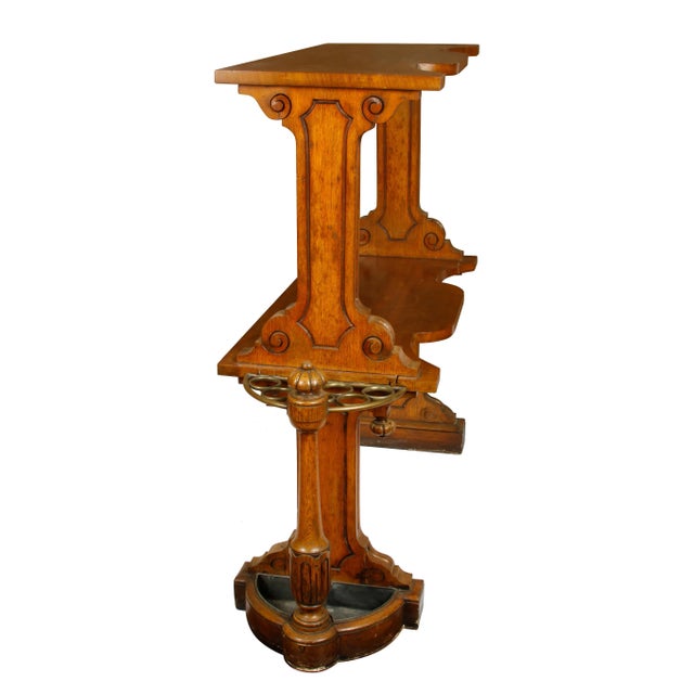 Antique English two-tier étagère hall stand with fluted design and rosette finial. Brass ringed umbrella holder on two sides.