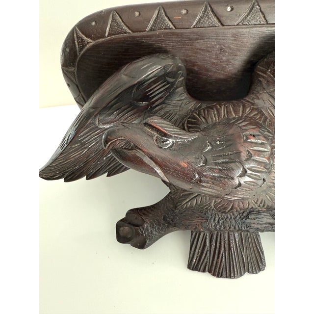 An eagle peers down underneath this dark wood Black Forest shelf that has a 13” x 8” area for your decor item to rest....