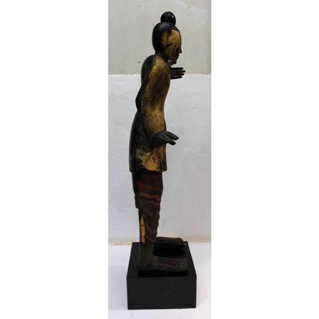 Antique Burmese standing carved wood Buddha statue on base. In a Mudras posture. Typical of Southeast Asian Buddhist art....