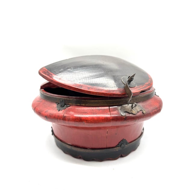 Dating to the early 20th century, circa 1900–1920, this striking antique Asian covered rice bowl is crafted of wood with a...