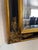 Mid-Century Large European Regency style, ornate black and gilt beveled mirror. The frame features a distinctive...