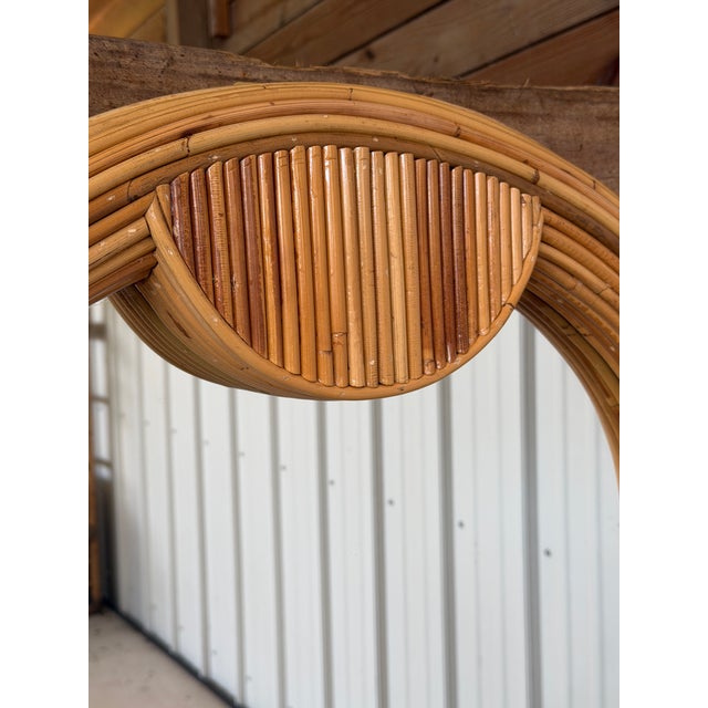 Absolutely stunning vintage pencil reed rattan wall mirror featuring a dramatic sculptural arched silhouette with layered...