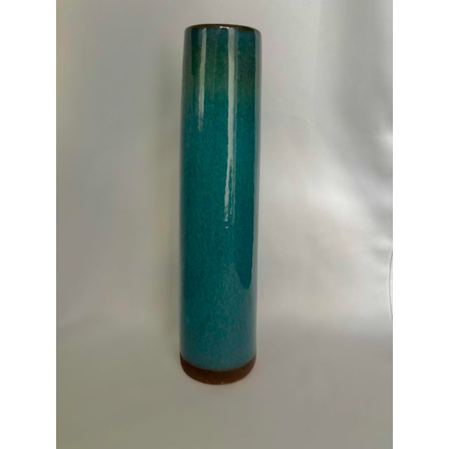 A striking vintage studio pottery vase featuring an elegant, elongated cylindrical silhouette and a richly variegated...
