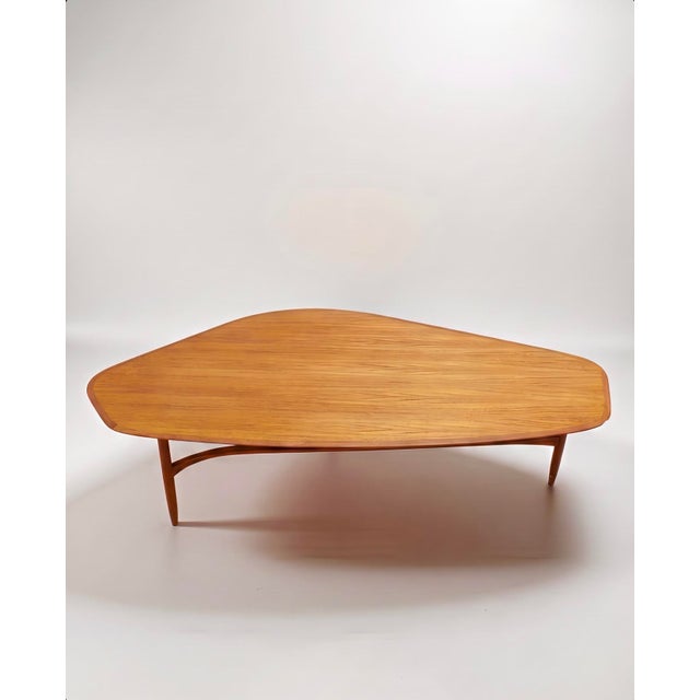 An exclusive and elegant coffee table in extra length, an original 1st-class vintage object from the 1950s, is offered...