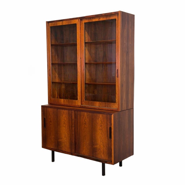 A stunning&nbsp; vintage storage piece, this tall cabinet is crafted in Brazilian rosewood with sliding glass doors, which...