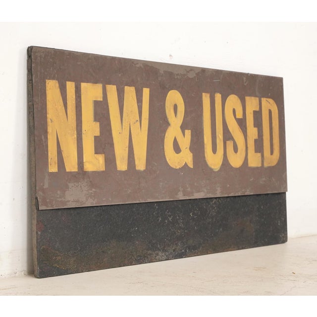 Reclaimed movie set sign made of aluminum on plastic foam board in yellow, brown, and black colors. The sign reads "New &...