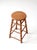 An antique primitive wooden stool featuring a rustic farmhouse silhouette, turned legs, and three tiers of stretchers. The...