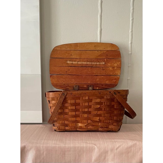 Vintage woven picnic basket with solid lid on hinge. This basket is a classic shape and texture and would be a great...