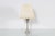 Stylish single light table lamp with nickel-plated brass base made up of two triangular pyramids, each slightly twisted,...