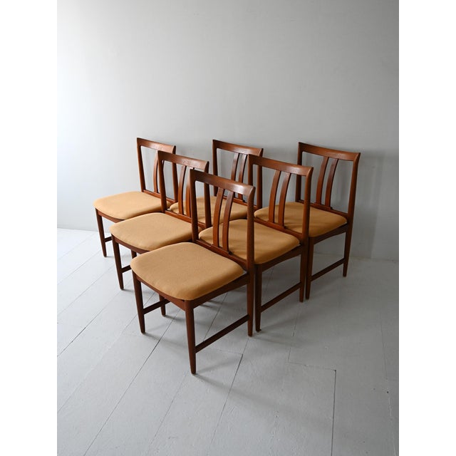 Set of six teak chairs with curved backrests and original zabaglione-colored upholstery. Elegant and well-proportioned...