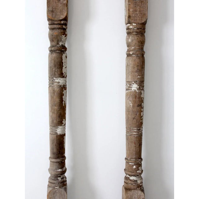 Pair of antique wooden architectural columns featuring turned wood posts with beautifully distressed white paint and a...