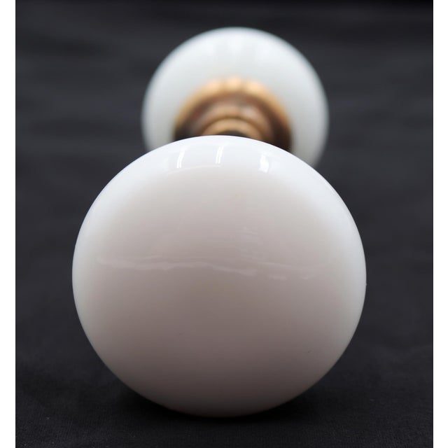 Vintage round white milk glass door knobs with a brass shank. Priced as a pair of knobs with a spindle. Good condition...