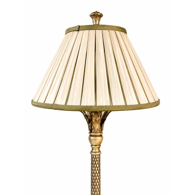 Elegant pair of Hollywood Regency tall table/buffet lamps featuring intricately carved bases with a silvered finish. The...