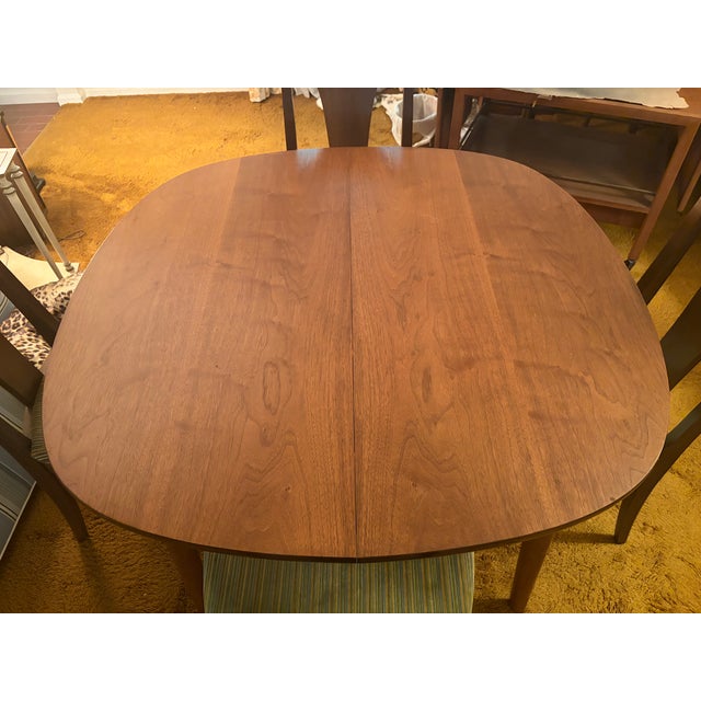 This 1960s walnut Parallel by Drexel dining set includes 2 leaves, 2 captains chairs and 4 regular chairs. There are light...