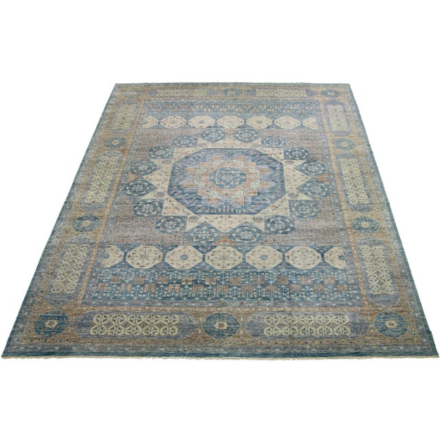 A Mamluk wool rug in a gray field with allover floral designs. This hand-knotted modern piece has blue and beige accents...