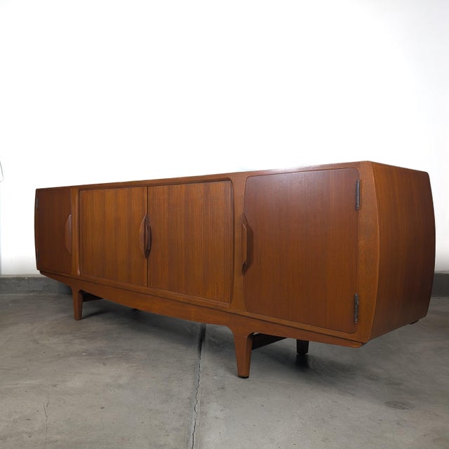 A rare and exceptional long-form Danish modern sideboard designed by Johannes Andersen for Uldum Møbelfabrik, executed in...