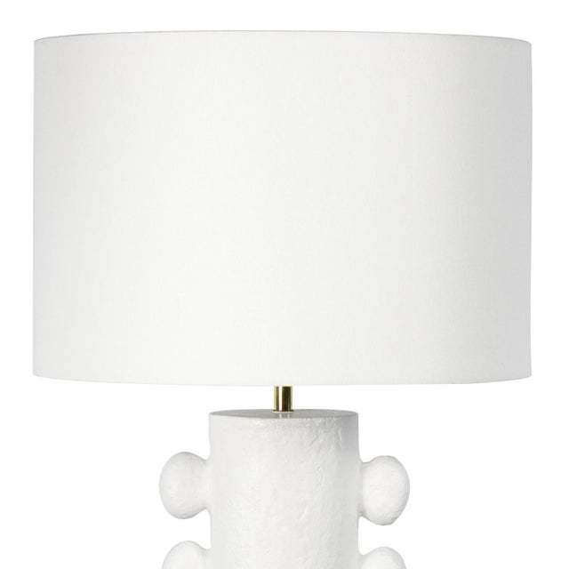The Sanya Table Lamp is rich with primitive, sculptural beauty. Sanya's cast metal body and matte paper maché finish is...
