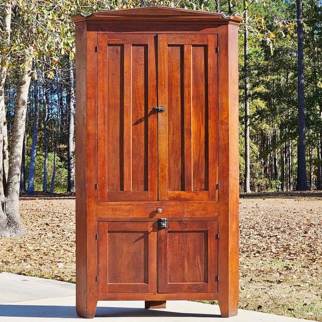 This is a stately and highly desirable antique Corner Cupboard that beautifully exemplifies the Country Federal or Federal...