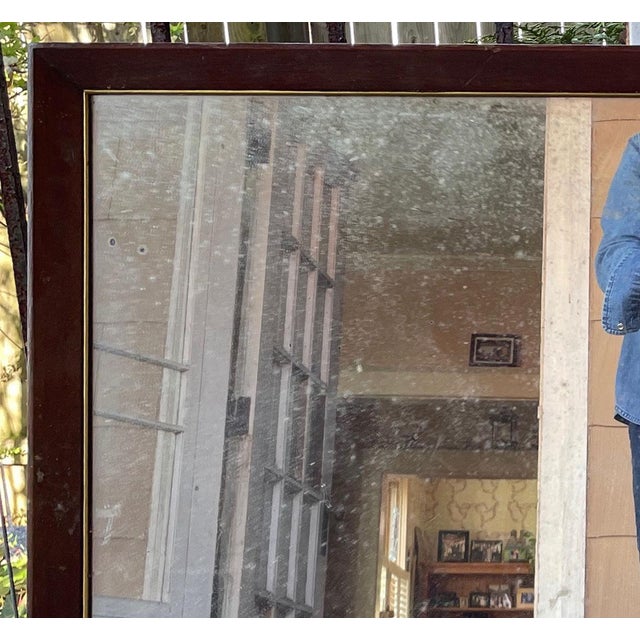 This is an antique mirror framed in wood with a gold colored filet accent. Backed with plywood for strength, it has some...