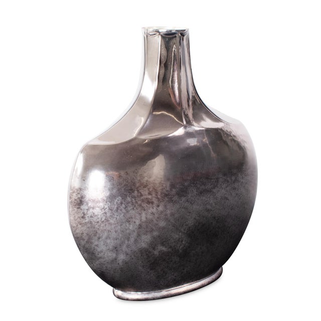 The Advik Polished Silver Vase is a refined piece crafted using century-old techniques in forging metals. Made from cast...
